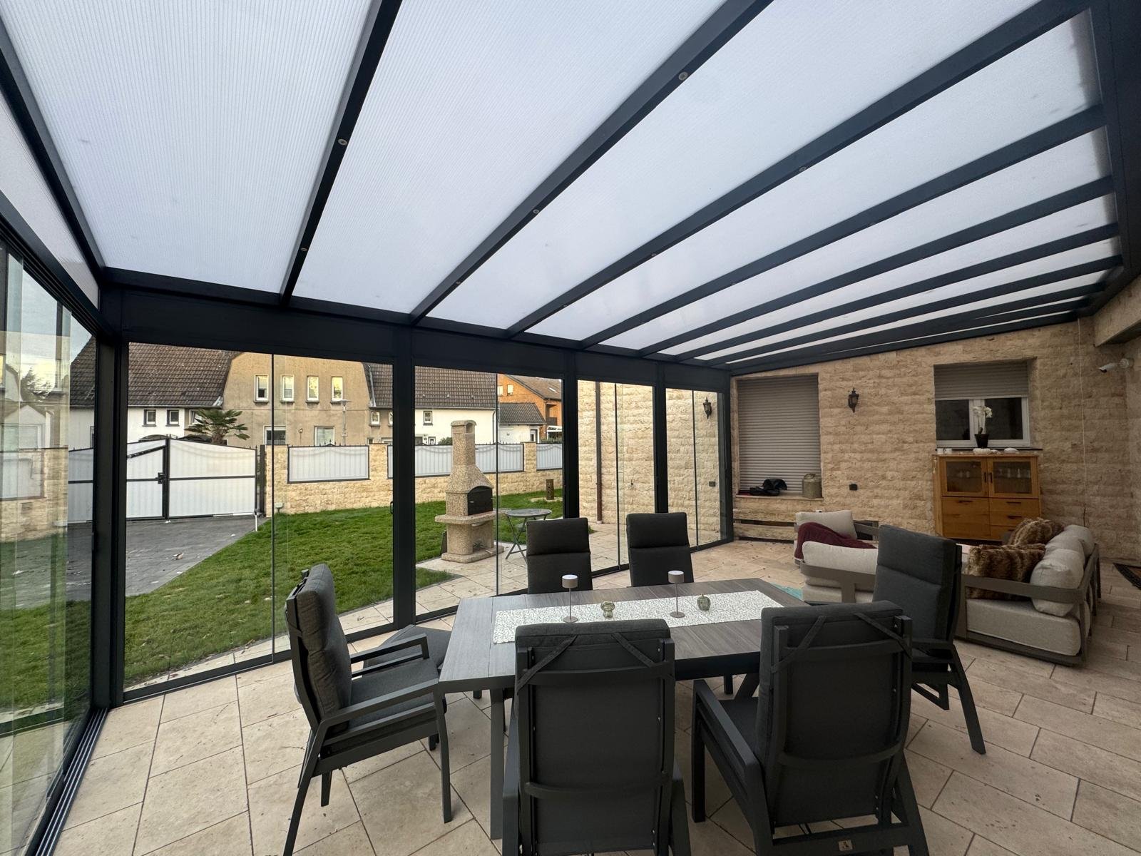 Veranda met glazen dak en zwarte profielen